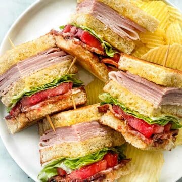 Club Sandwich with toothpicks on plate with potato chips foodiecrush.com