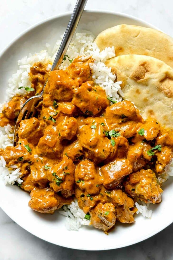 Indian Butter Chicken over rice with naan in bowl foodiecrush.com