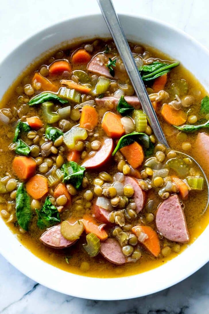 Lentil Soup Recipe with kielbasa and spinach in bowl with spoon foodiecrush.com